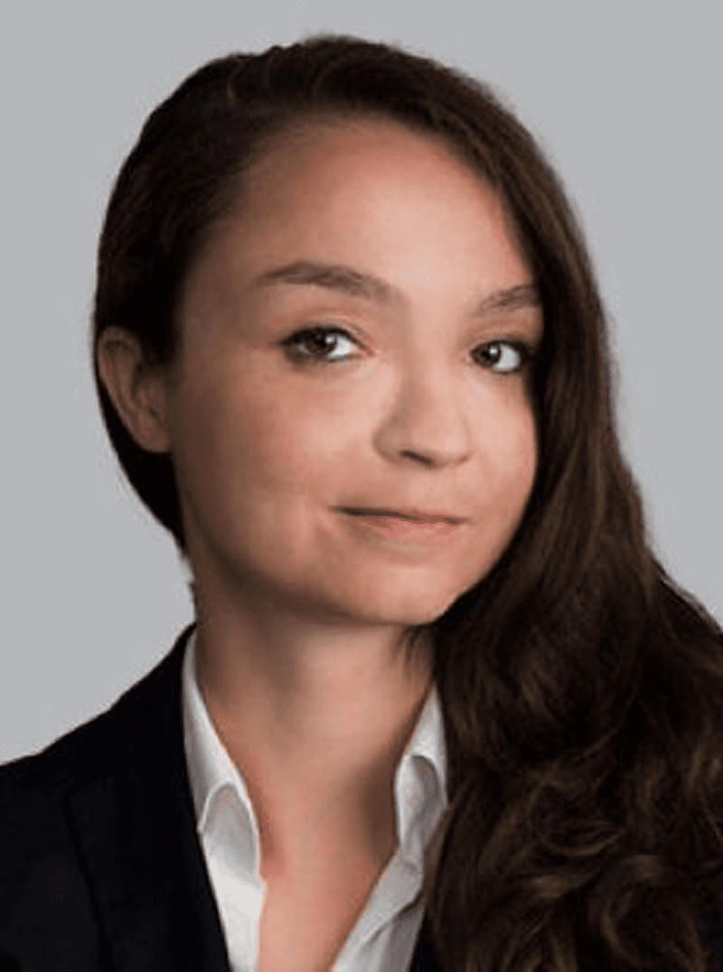 Professional woman with long brown hair and a confident expression.