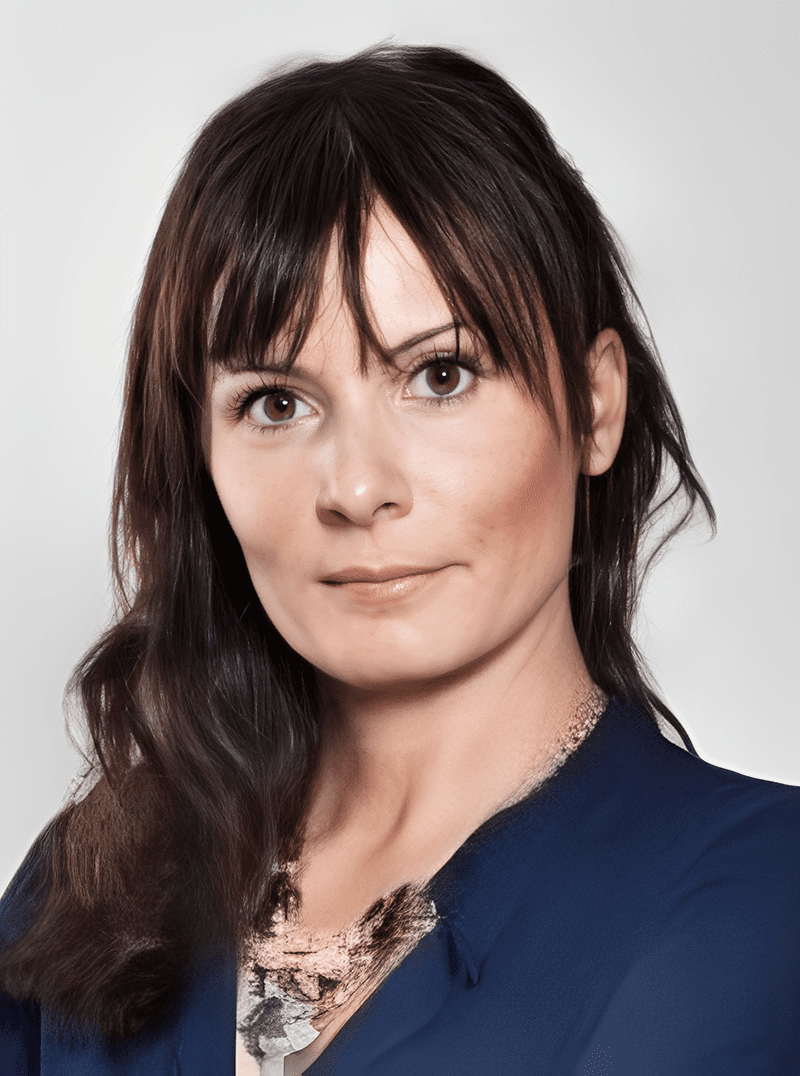Professional woman with dark hair wearing a navy blue top.